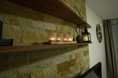 a stone wall with candles on a shelf at Apartman BIG Milmari S19 in Kopaonik