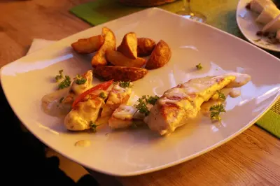 a plate of food with fish and potatoes on a table at Apartman BIG Milmari S19 in Kopaonik