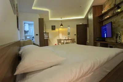 a large white bed in a room with a television at Apartman BIG Milmari S19 in Kopaonik