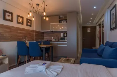 a living room with a blue couch and a kitchen at Premier 29 Milmari Resort Wellness&Spa in Kopaonik