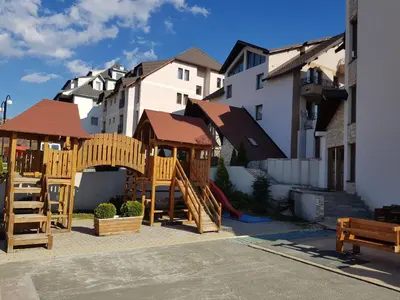 a playground with a wooden play set and buildings at Premier 29 Milmari Resort Wellness&Spa in Kopaonik