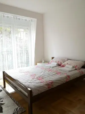 a bed in a bedroom with a large window at Apartman Downtown in Vrnjačka Banja