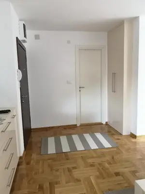 a white room with a door and a wooden floor at Apartman Downtown in Vrnjačka Banja