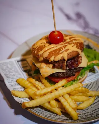 a hamburger and french fries with a cherry on top at Apartman Downtown in Vrnjačka Banja