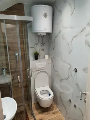 a bathroom with a white toilet and a sink at Vila Plan centar Kopaonik in Kopaonik