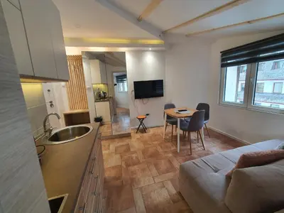 a kitchen and living room with a couch and a table at Vila Plan centar Kopaonik in Kopaonik