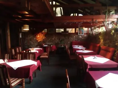 a restaurant with red tables and chairs in a room at Malgo in Vrnjačka Banja