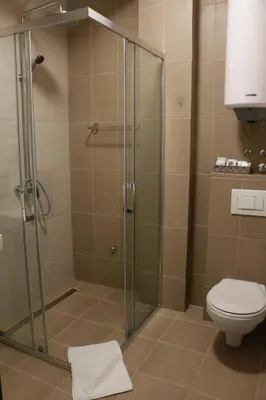 a shower stall with a toilet in a bathroom at Vila Lucky Kop & Restoran in Kopaonik