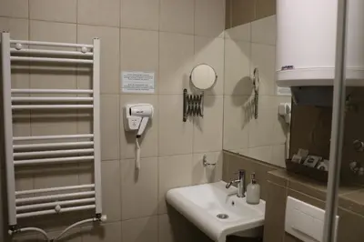 a bathroom with a sink and a phone on the wall at Vila Lucky Kop & Restoran in Kopaonik