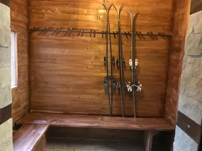 a wooden wall with skis sitting on a bench at Vila Lucky Kop & Restoran in Kopaonik