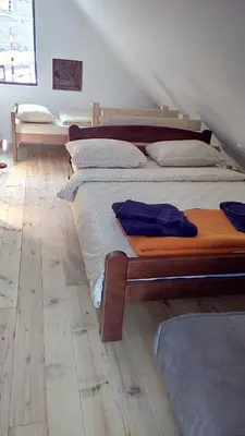 two beds in a room with a wooden floor at Sky 3 in Kopaonik
