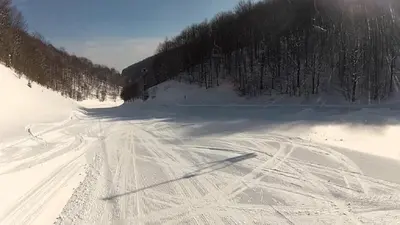 a snow covered road with ski tracks in the snow at Vila Košuta - Kopaonik, Brzeće 30m from gondola in Brzeće