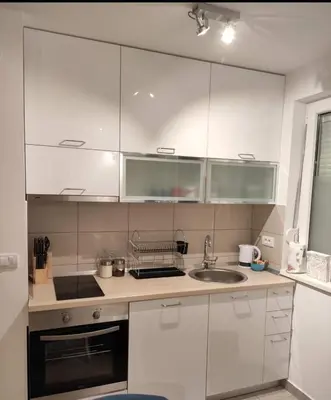 a kitchen with white cabinets and a sink at Apartman Beker Vrnjacka Banja in Vrnjačka Banja