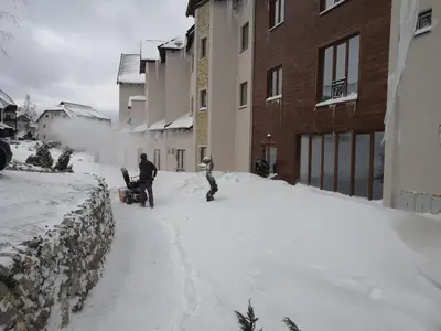 a man and a child standing in the snow at Apartment Sunny Valley Milmari S-9 in Kopaonik