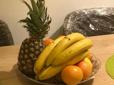 a bowl of fruit with a pineapple and oranges at Apartment Sunny Valley Milmari S-9 in Kopaonik