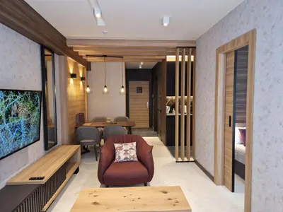 a living room with a chair and a table at Select Lux Woodside Residences & SPA in Kopaonik