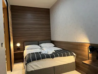 a bedroom with a bed with a wooden wall at Select Lux Woodside Residences & SPA in Kopaonik