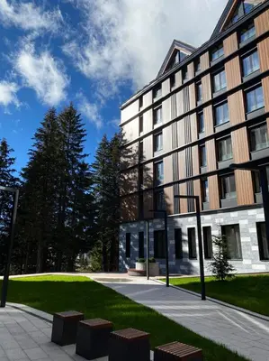 a large building with a lawn in front of it at Select Lux Woodside Residences & SPA in Kopaonik