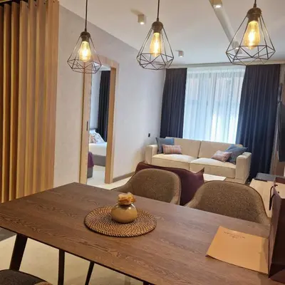 a living room with a table and chairs and a living room at Select Lux Woodside Residences & SPA in Kopaonik