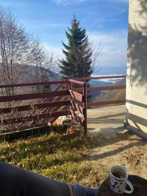 a cup of coffee sitting on a table next to a fence at Weekendica in Kopaonik