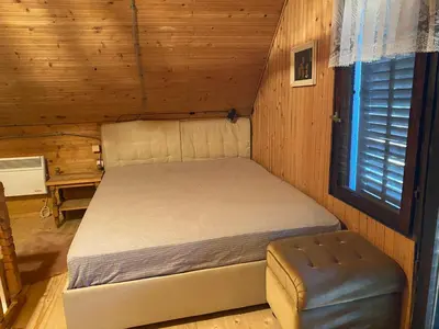 a bedroom with a bed in a wooden cabin at Weekendica in Kopaonik