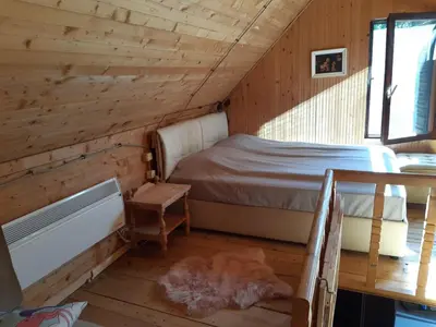 a bedroom with a bed in a wooden cabin at Weekendica in Kopaonik