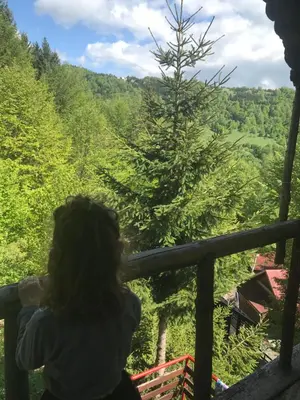 a woman standing on a balcony looking out at the forest at Weekendica in Kopaonik