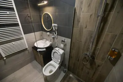 a bathroom with a toilet and a sink and a mirror at Corner Apartmani in Leskovac