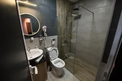 a bathroom with a toilet and a sink and a shower at Corner Apartmani in Leskovac