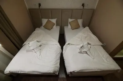 two beds sitting next to each other in a room at Corner Apartmani in Leskovac