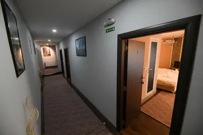 a hallway with a door leading to a bedroom at Corner Apartmani in Leskovac