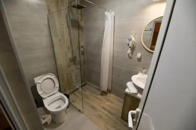 a bathroom with a toilet and a shower and a sink at Corner Apartmani in Leskovac