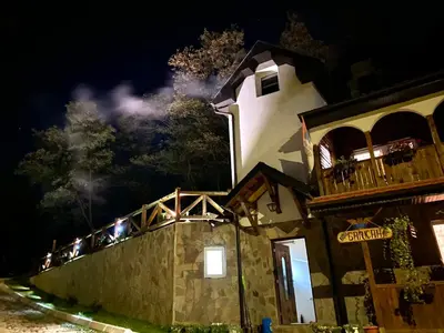 a building with people on the balcony at night at Kuca za odmor ,,Balkan” in Crni Vrh