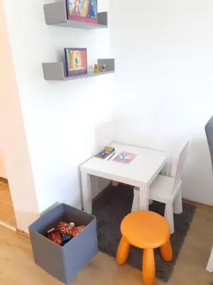 a small white table and a stool and a box of fruit at Anilux studio in Vrnjačka Banja