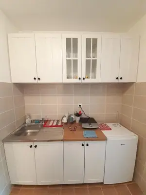 a kitchen with white cabinets and a sink at Anilux studio in Vrnjačka Banja