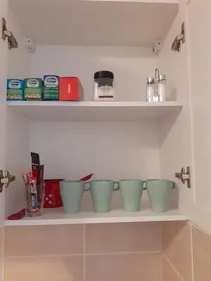 a row of green bowls on a shelf in a kitchen at Anilux studio in Vrnjačka Banja