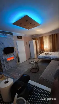 a living room with a bed and a blue light at Apartman Iva in Zaječar