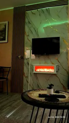a living room with a table and a tv on a wall at Apartman Iva in Zaječar