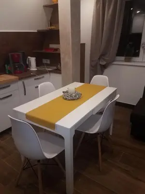 a white and yellow table and chairs in a kitchen at Apartman Tea in Kopaonik