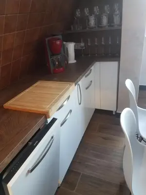 a kitchen with white cabinets and a wooden counter top at Apartman Tea in Kopaonik