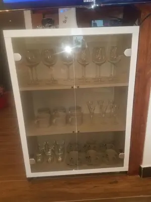 a cabinet full of wine glasses and dishes at Apartman Tea in Kopaonik