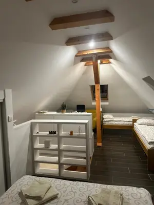 a attic room with two beds and a dresser at Apartman Tea in Kopaonik