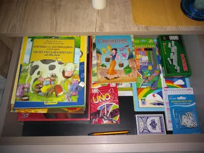 a table topped with childrens books and other toys at Pčelica L15 Milmari in Kopaonik