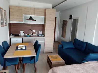 a living room with a blue couch and a table at Pčelica L15 Milmari in Kopaonik