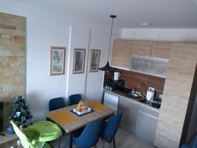a small kitchen with a table and blue chairs at Pčelica L15 Milmari in Kopaonik