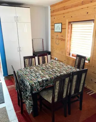 a dining room with a table with chairs and a tableablish at Apartman Tanja in Kopaonik
