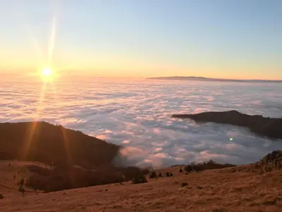 a view of the sun rising over a sea of clouds at Apartman Tanja in Kopaonik