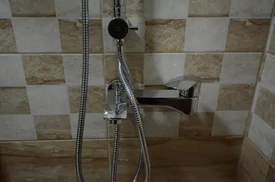 a shower in a bathroom with a hose at Cvetkovic LUX Аpartmani & Free GARAŽA in Vrnjačka Banja