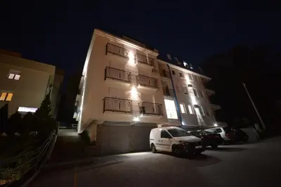 a white car parked in front of a building at night at Cvetkovic LUX Аpartmani & Free GARAŽA in Vrnjačka Banja