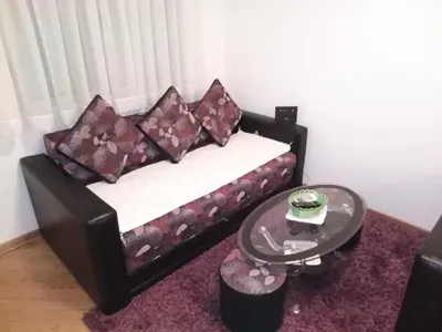 a couch with pillows and a table in a room at FEEL LIKE HOME in Vrnjačka Banja